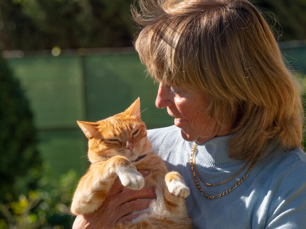 Claudine de profil, le chat roux dans les bras