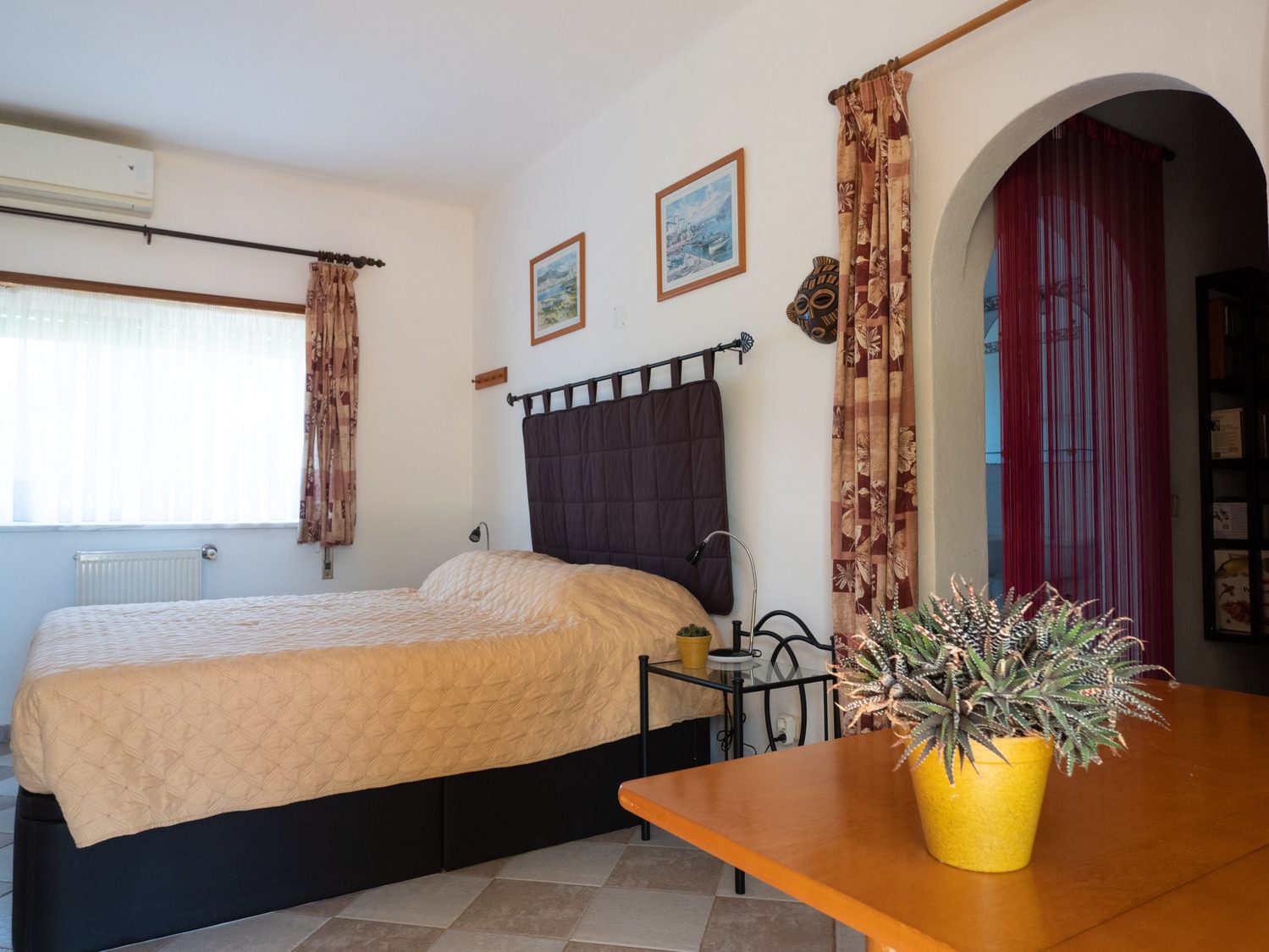 La chambre vue depuis le coin repas, le lit et l'arche vers la salle de bain