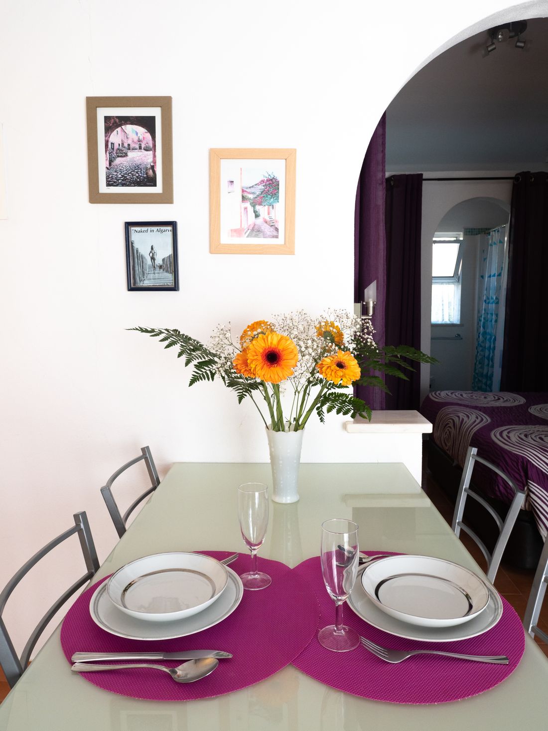 La table du coin repas dressée pour deux, devant la kitchenette